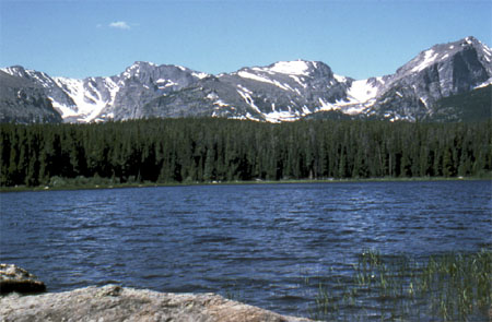 Snow-covered mountains behind a lake.